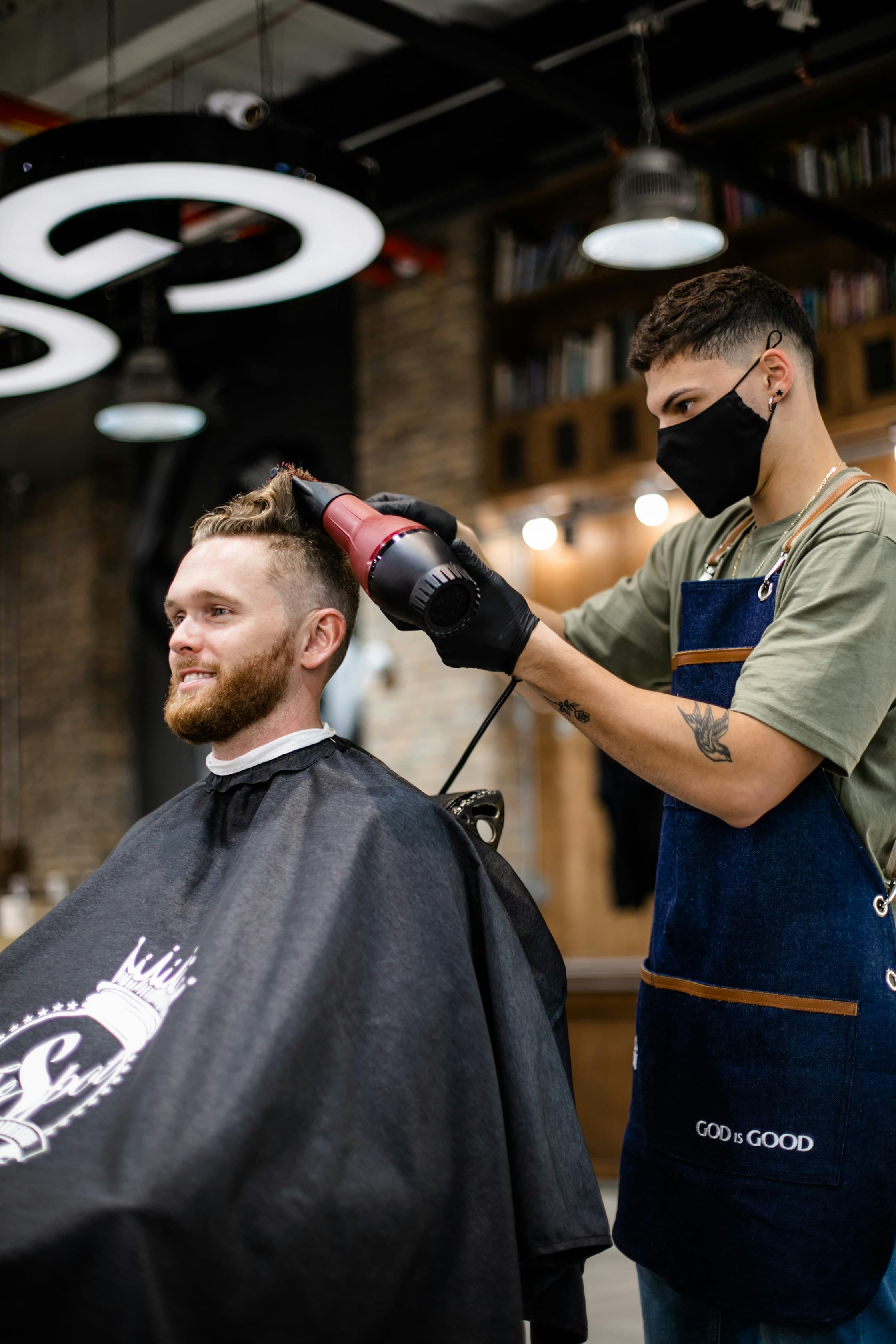 Hairstylist cutting blonde hair with scissors