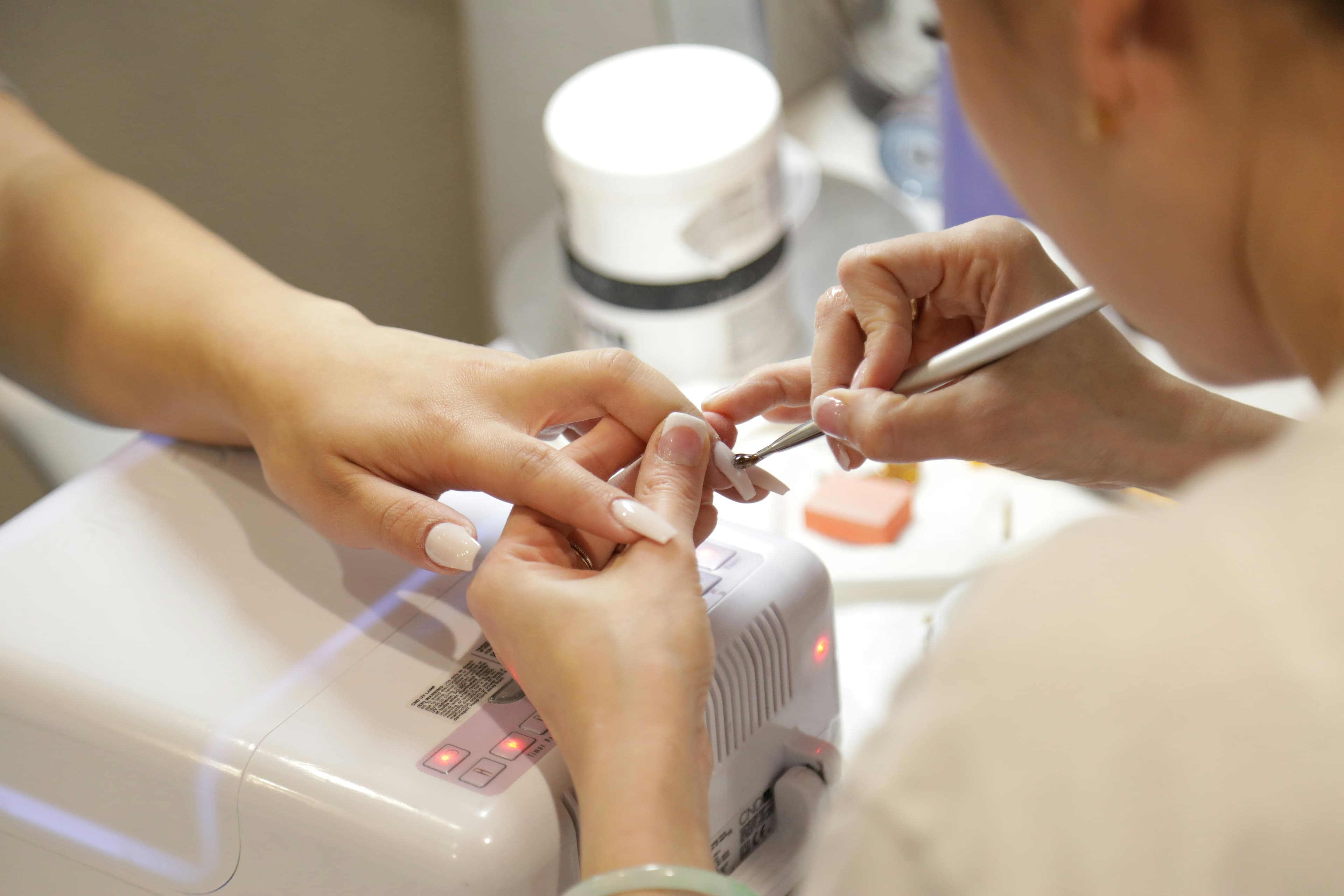 Nail technician applying polish during a manicure
